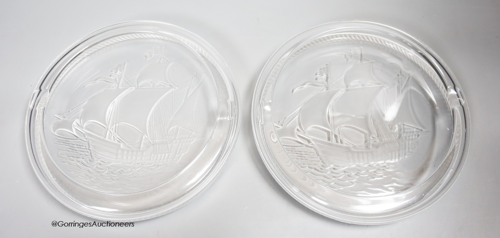 Two Lalique glass 'Santa Maria' ashtrays, moulded with clippers, signed, diameter 17cm